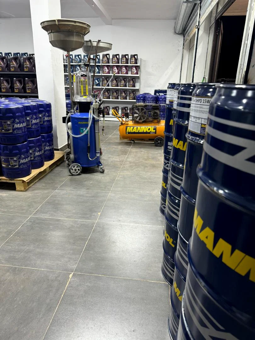 Fûts MANNOL de 200 litres empilés dans l'entrepôt de Bamako, avec station de vidange et compresseur